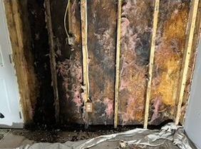 A room with a wall that has been damaged by a fire.