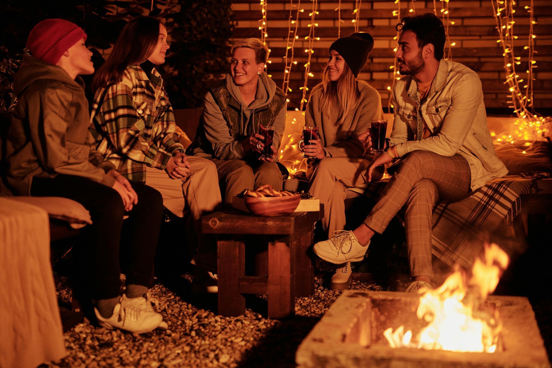A group of people are sitting around a fire pit.