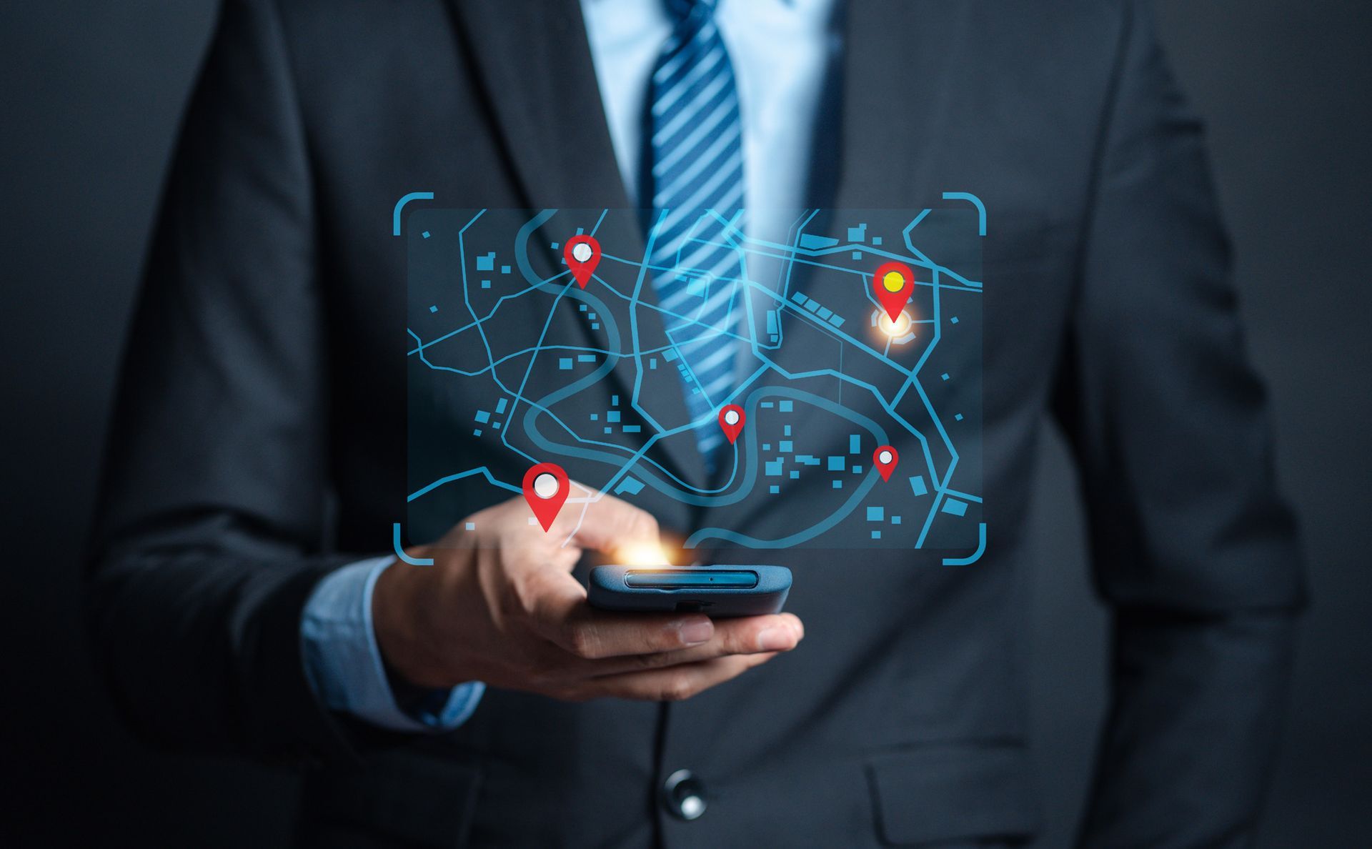 A man in a suit and tie is holding a cell phone.
