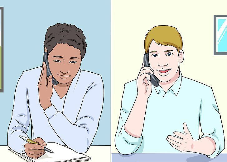 Two people talking on the phone at desks, separated by a vertical divider.