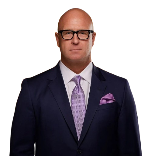 Portrait of a bald man in glasses wearing a navy suit with a lavender tie and pocket square