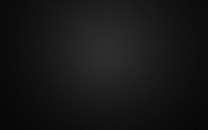 Dark, nearly black textured surface with a faint circular glow in the center.