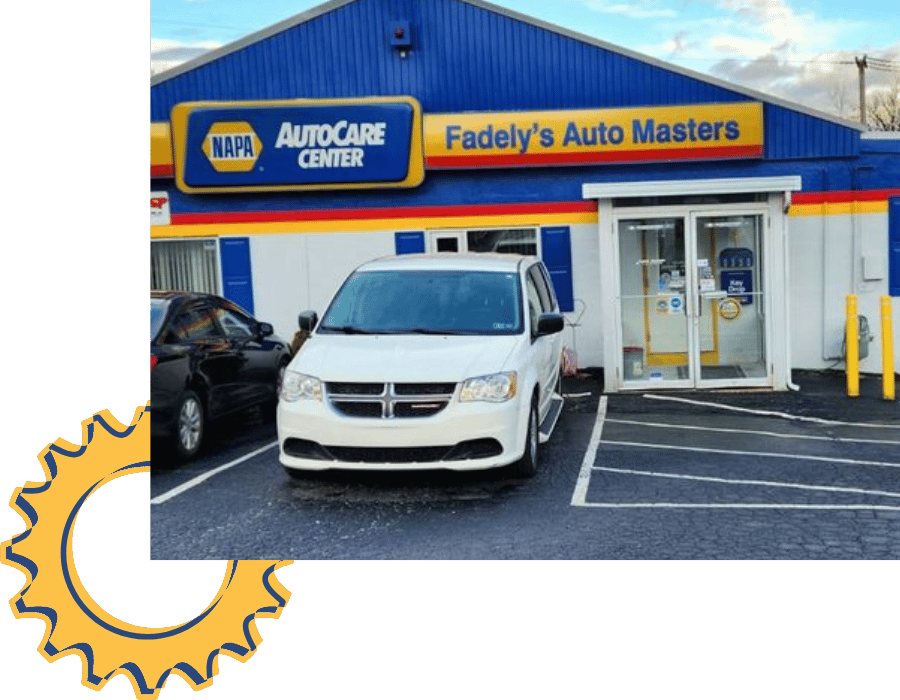 White Dodge minivan parked outside Fadely’s Auto Masters NAPA AutoCare Center.
