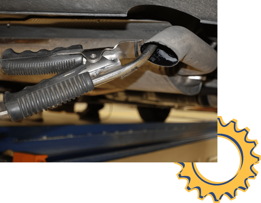 Technician using exhaust clamp tool during vehicle exhaust system repair service.