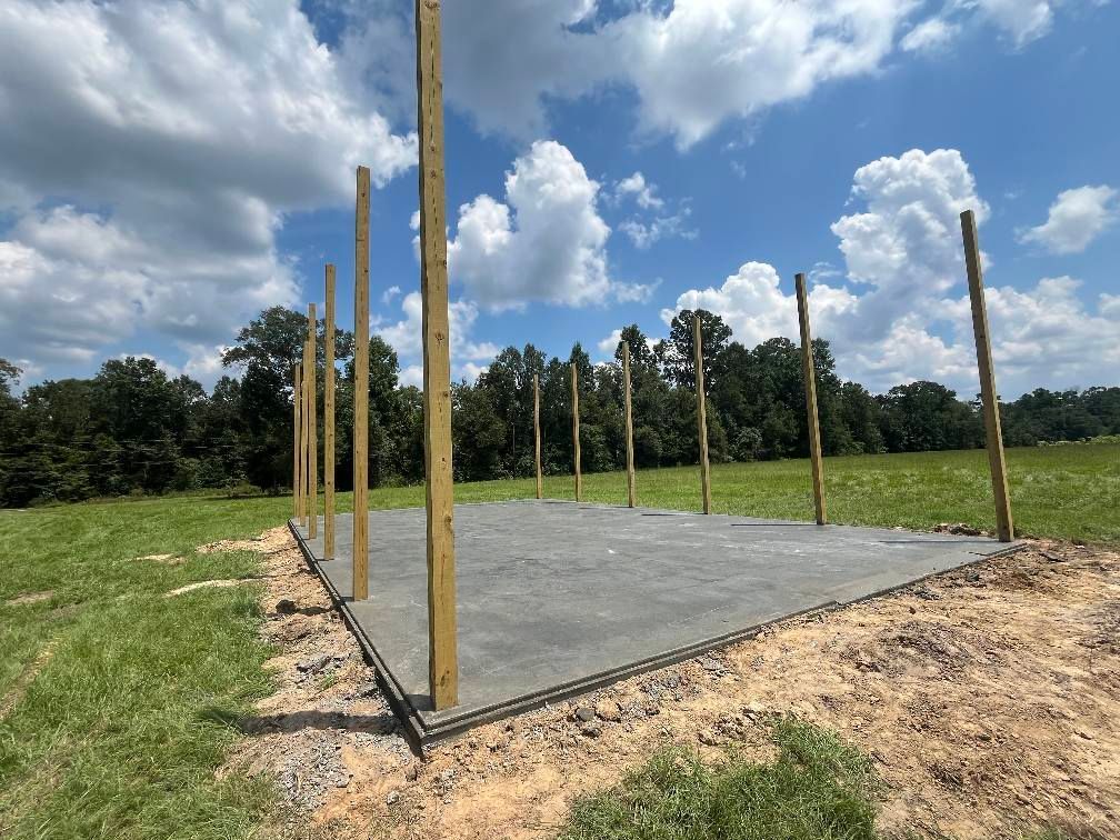 Concrete slab with wooden posts, in a field on a sunny day.
