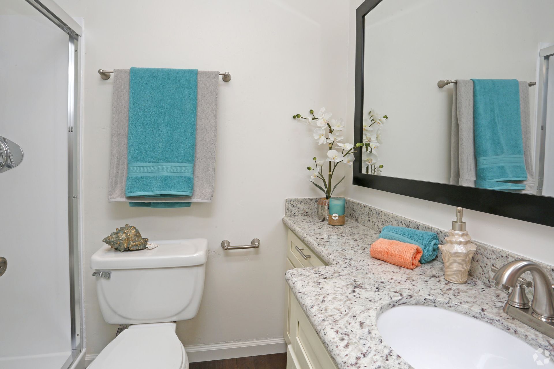 A bathroom with a toilet , sink and mirror
