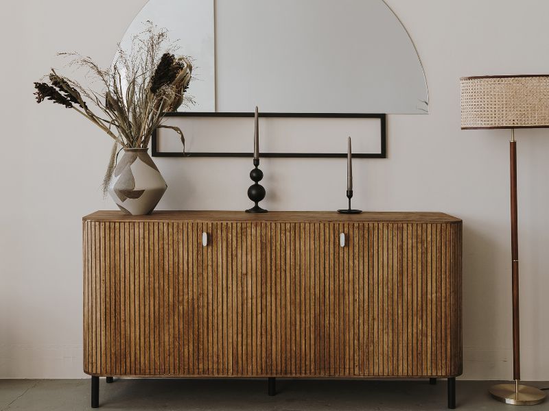 Modern sideboard with decor, dried flowers, and lamp in a minimalist room