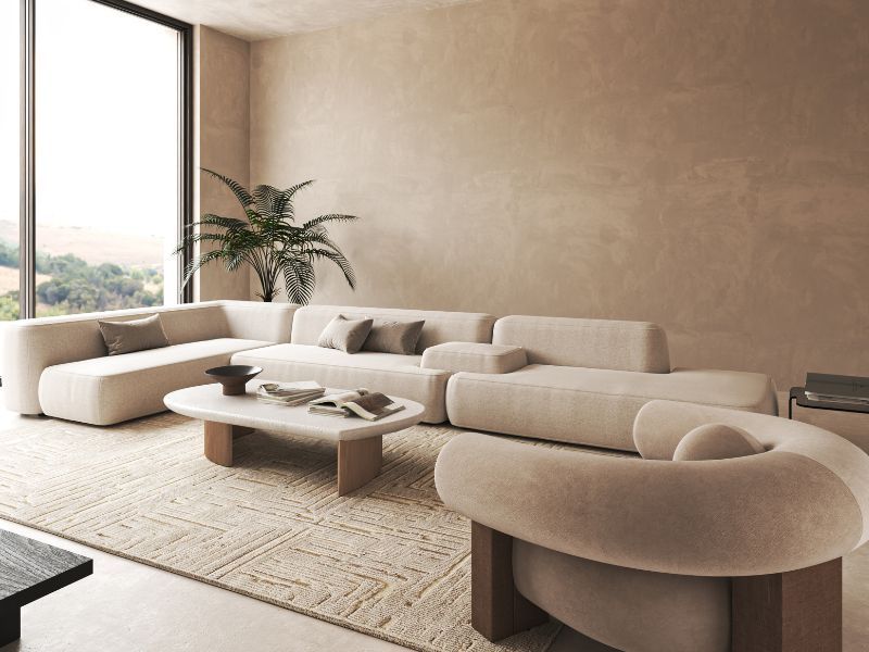 Modern minimalist living room with cream curved sofas, low coffee table, and large window light