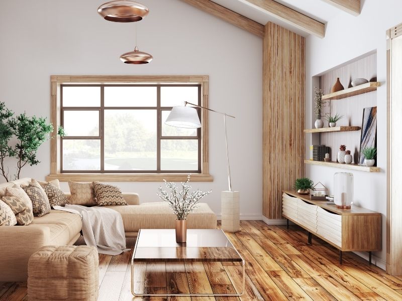 Bright, airy living room with beige sofa, wooden coffee table, large window, and shelves on the right