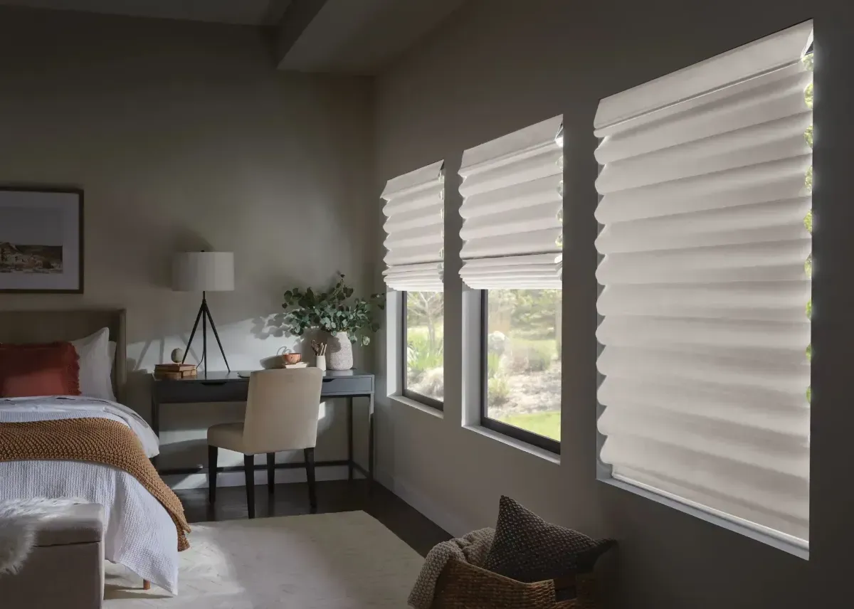 White window blinds with light casting soft shadows against a gray wall.