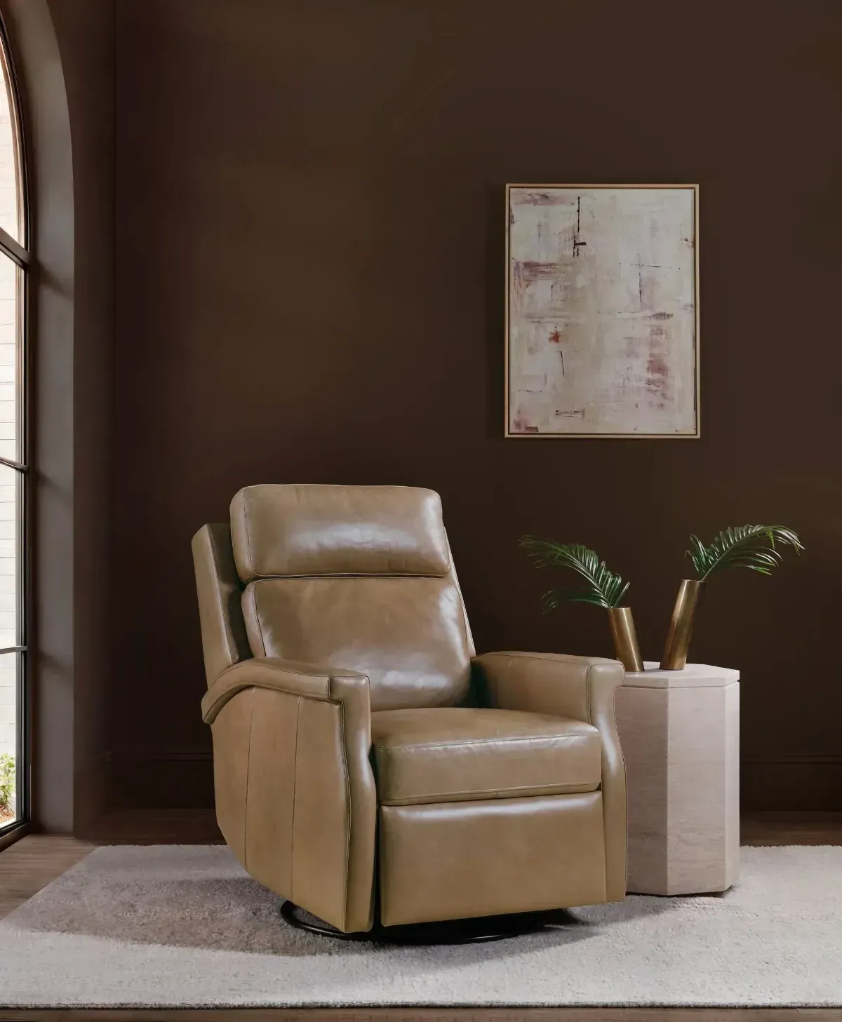Beige loveseat with two teal pillows in a bright living room, with a circular wall mirror above.