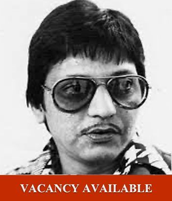 Black-and-white portrait of a man in sunglasses above a red banner reading “VACANCY AVAILABLE”