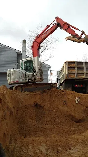 Excavator loading dirt into a truck at a construction site