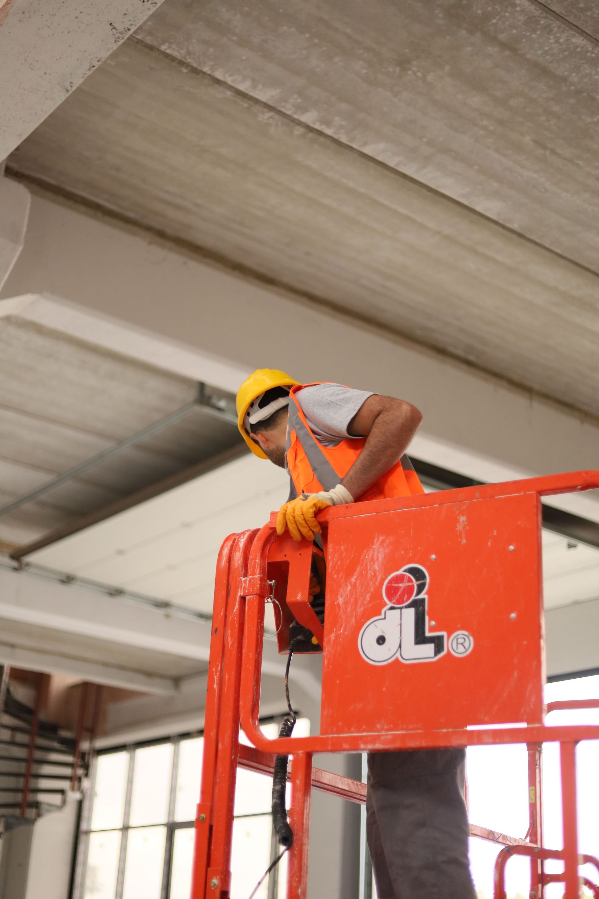 rigging worker orange lift platform in an industrial ceiling area