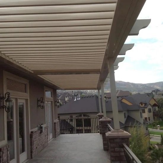 Covered front porch overlooking suburban homes and mountains under a cloudy sky