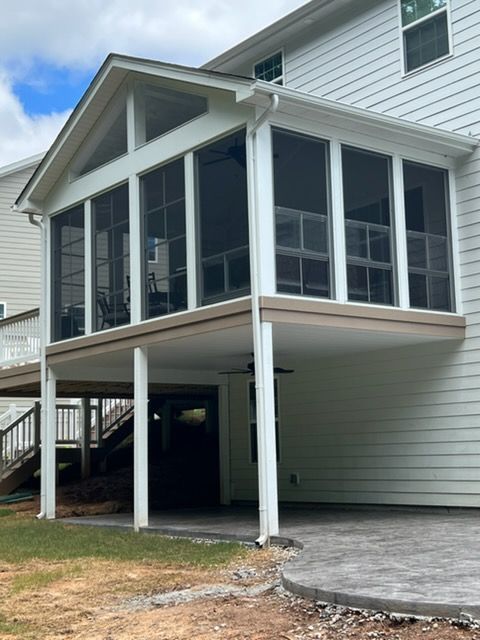 Raised screened porch on a white house with stairs and support posts