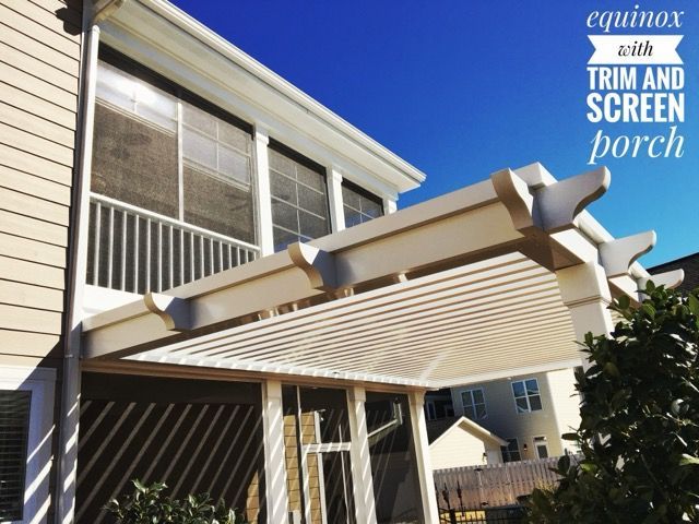 Residential porch with white awning and retractable screen shades on a sunny house exterior