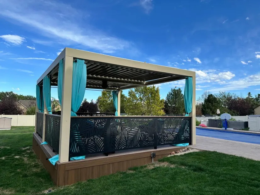 Outdoor gazebo with teal curtains and black privacy panels in a grassy yard under a blue sky