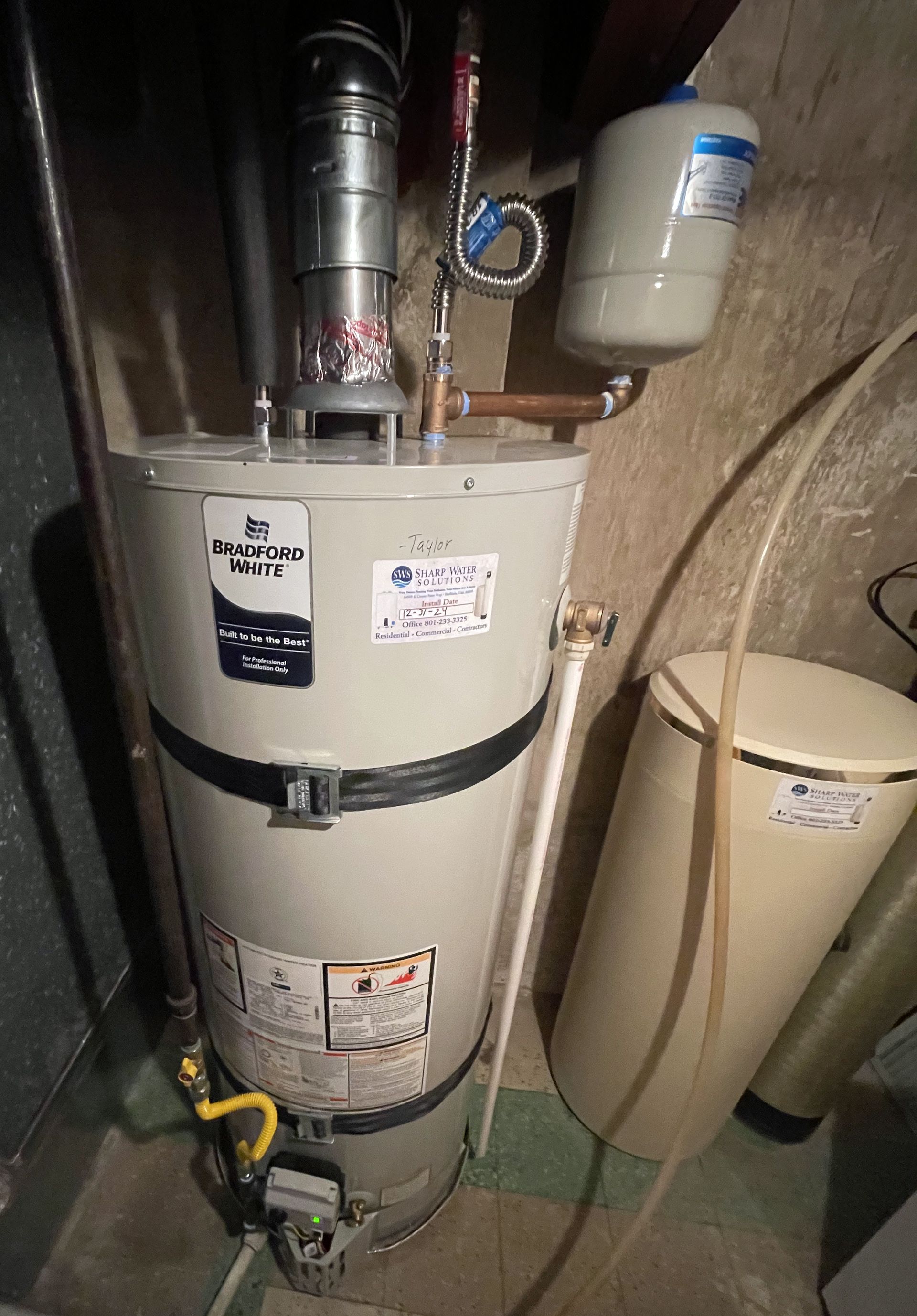 Sharp Water Solutions installing water heater replacement in Davis County residential utility closet for reliable hot water.