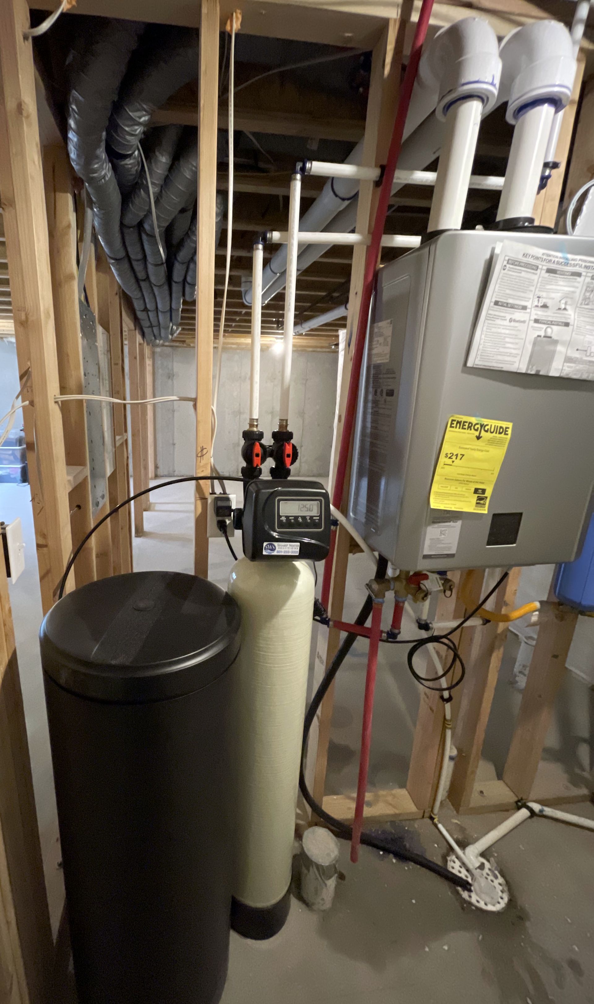 Sharp Water Solutions installing efficient tankless water heaters in Utah County residential basement for reliable hot water.