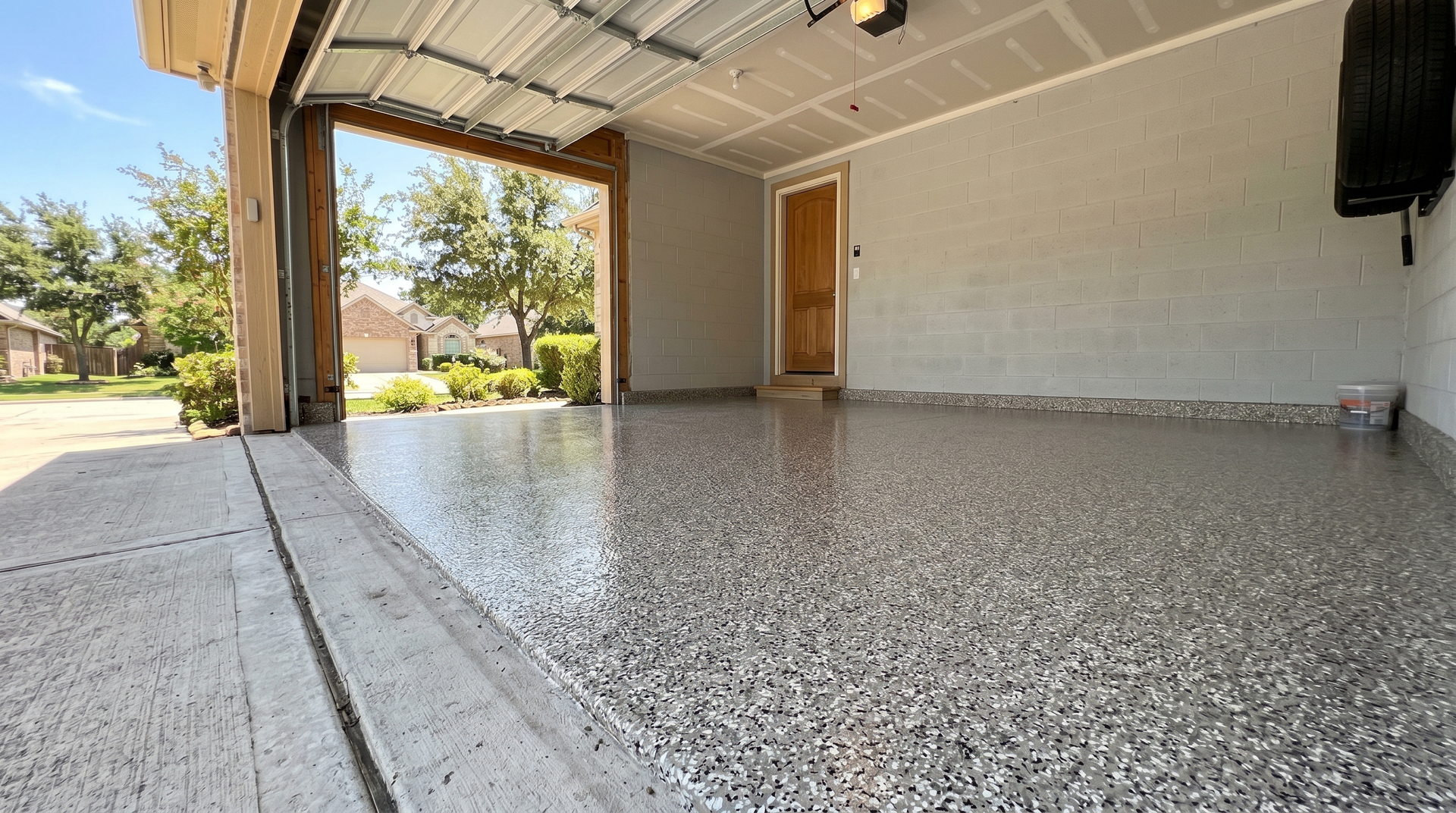 Covered porch with a speckled concrete floor, white walls, and an open view to the yard.