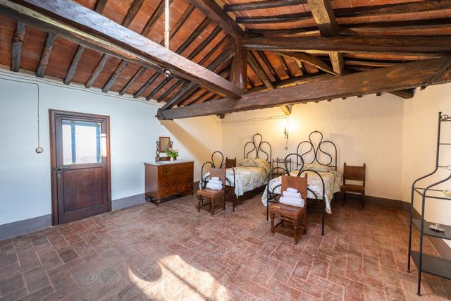 Camera da letto rustica con due letti singoli in ferro battuto.