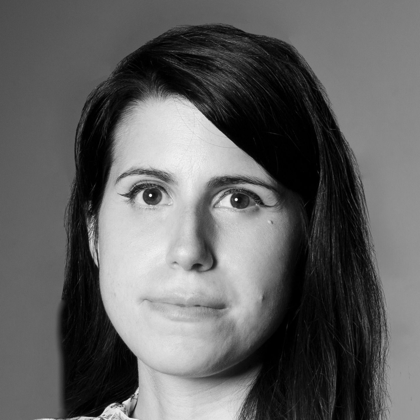 Black-and-white headshot of a person with dark hair, facing forward with a neutral expression
