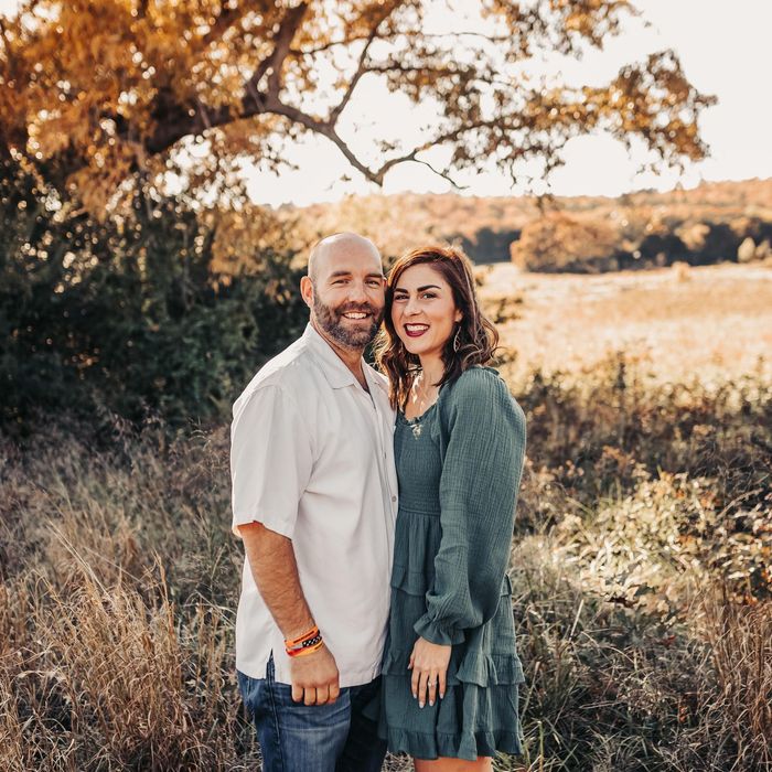 a man and a woman are posing for a picture in a field .