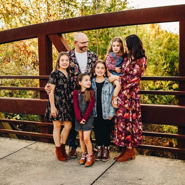 a family is posing for a picture on a bridge .