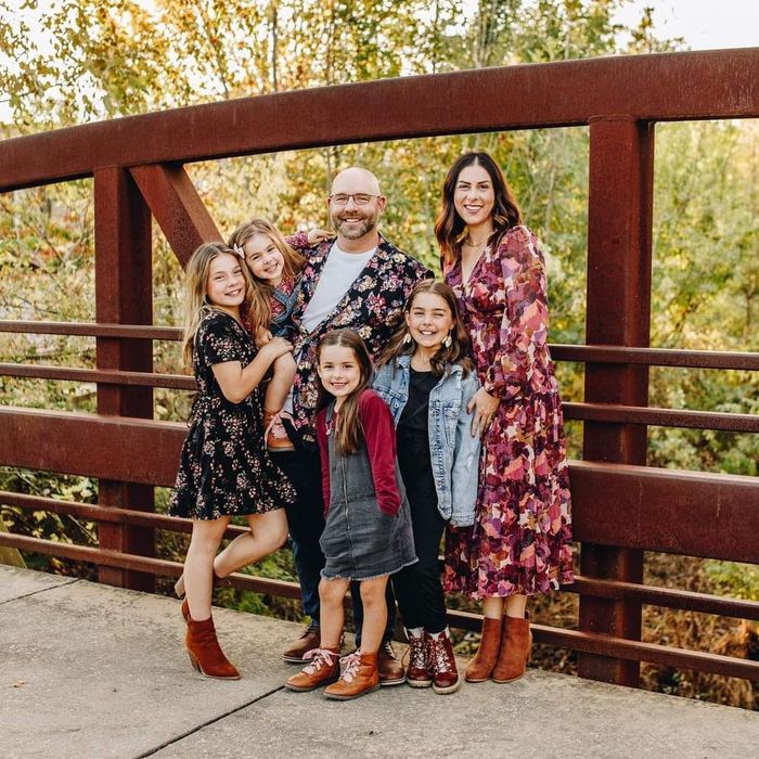 a family is posing for a picture on a bridge .
