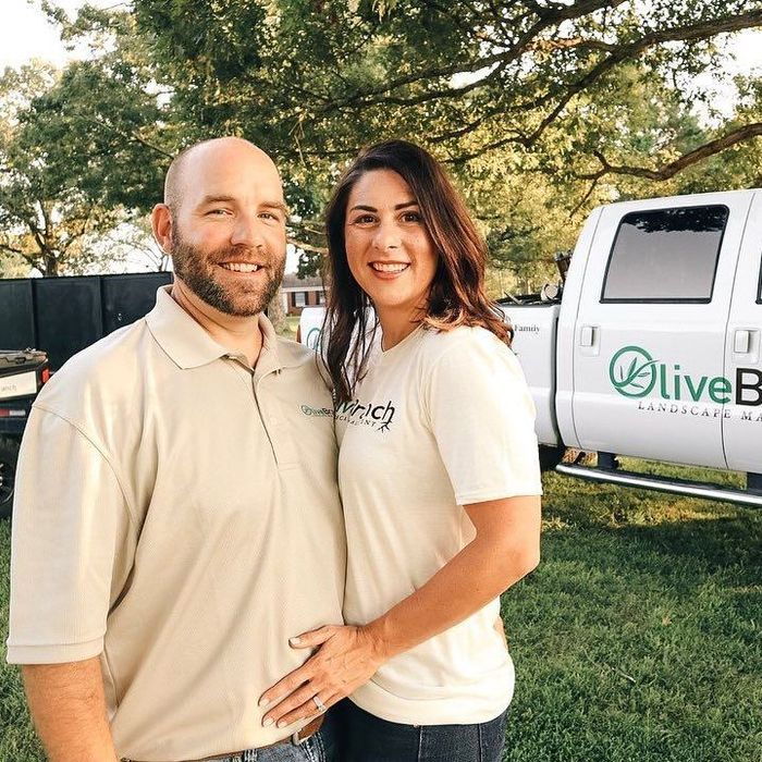 a man and a woman are posing for a picture in front of a truck .