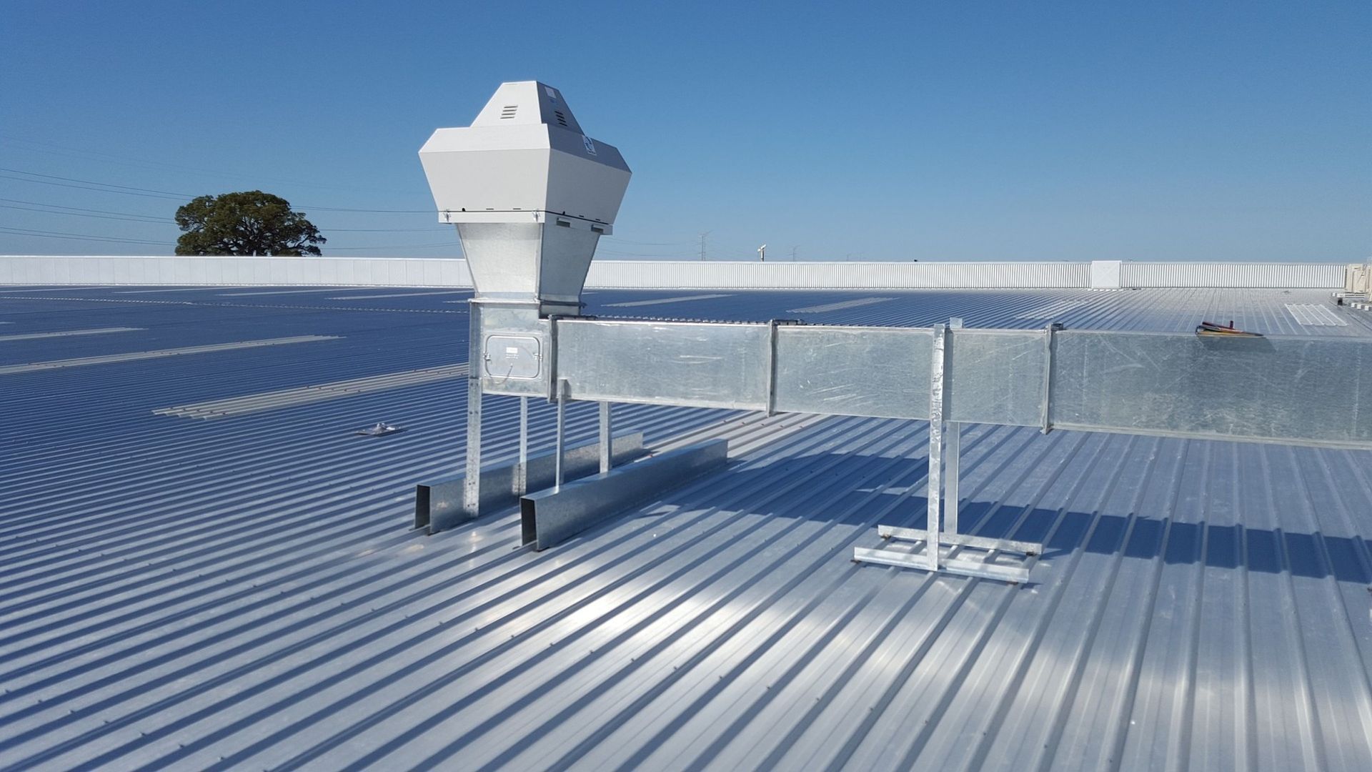 A metal roof with a ventilation system attached to it