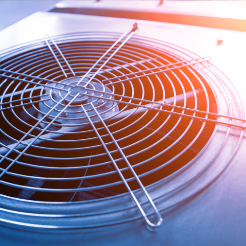 A close up of an air conditioner fan with the sun shining through it