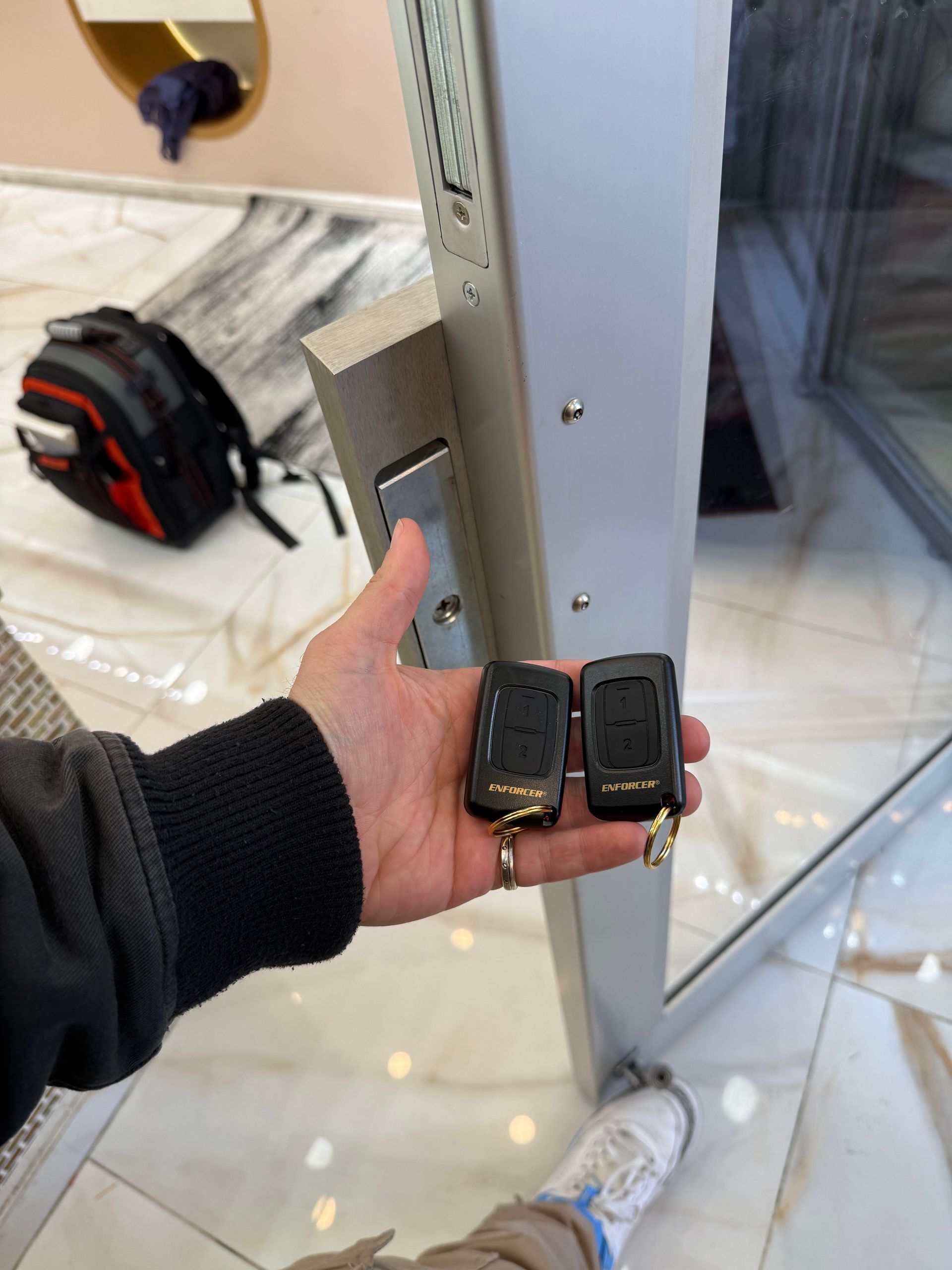 A man in a blue shirt uses a key to open a metal cabinet door.