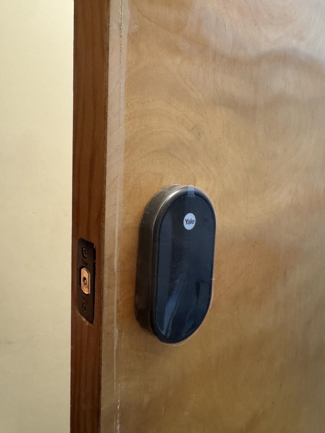 A man in a blue shirt uses a key to open a metal cabinet door.