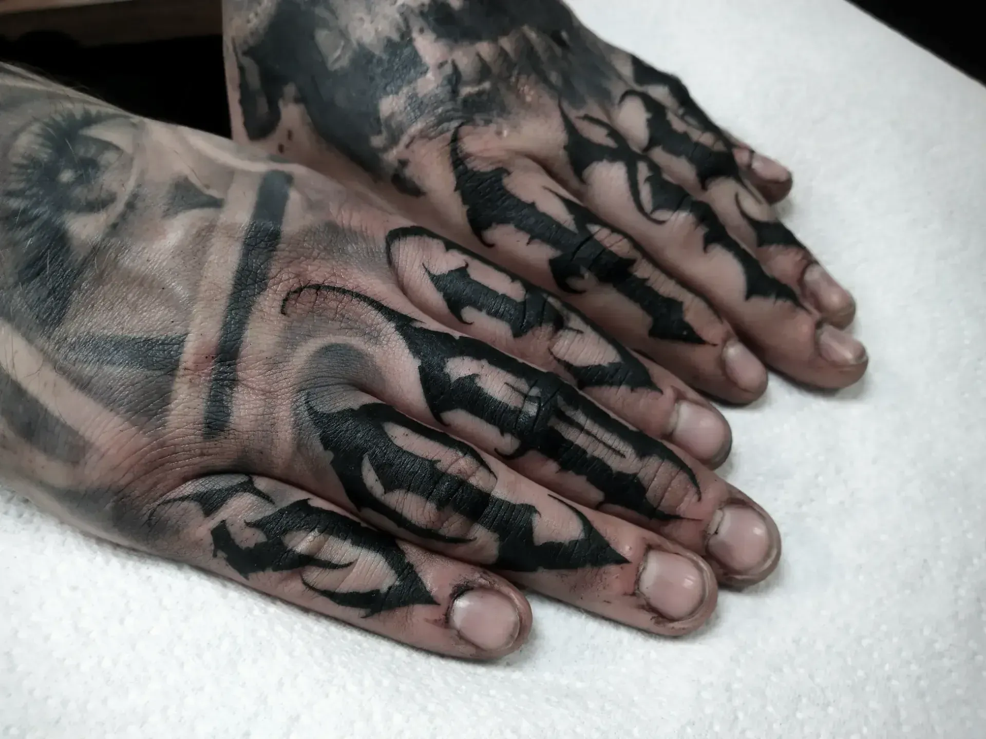 Dark lettering freehand tattoo — bio-organic design
drawn directly onto skin by Crawlspace Tattoo Artist based in London