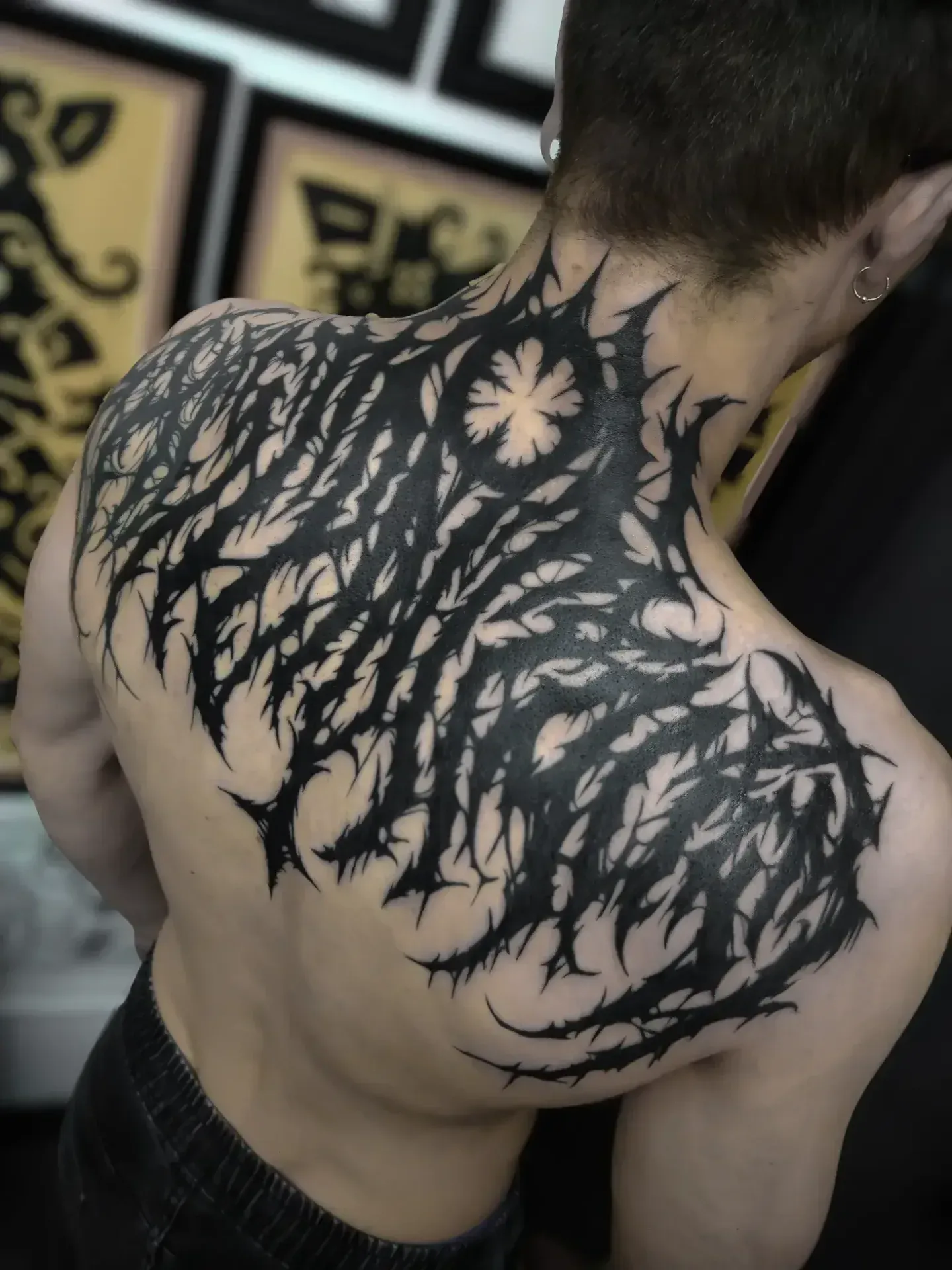 Dark lettering surrealism freehand tattoo — bio-organic design
drawn directly onto skin