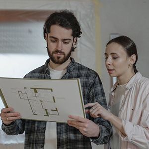 Two people reviewing a floor plan together indoors