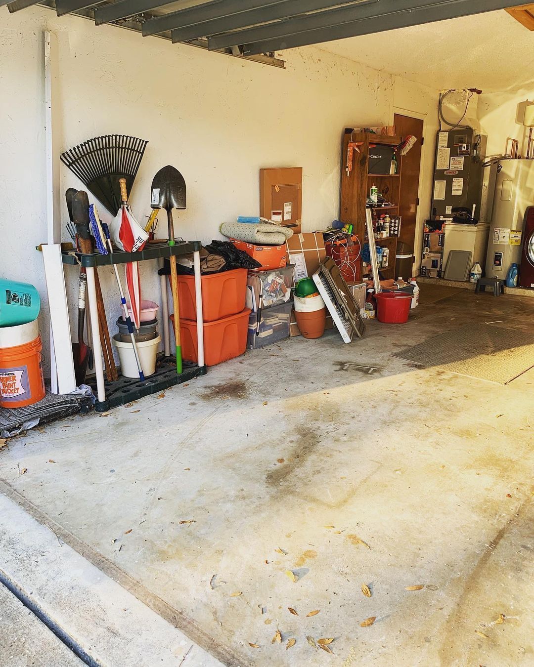 A messy garage with a bucket that says ' bucket ' on it