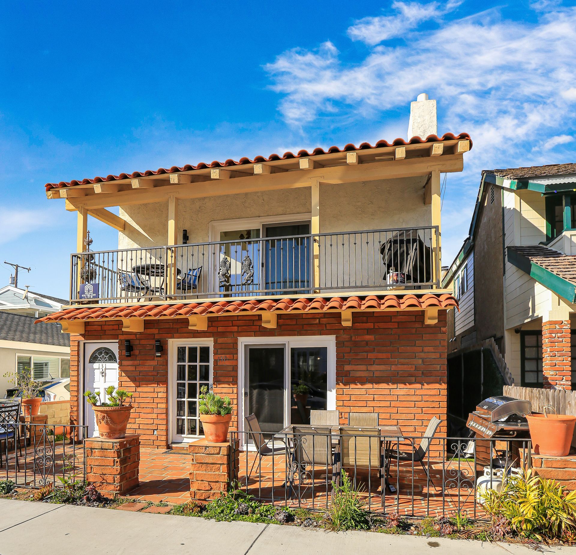 A brick house with a balcony on the second floor