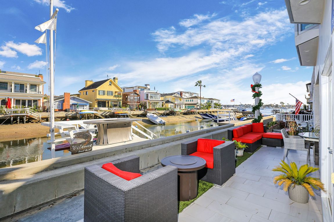 A balcony overlooking a body of water with a lot of furniture on it.
