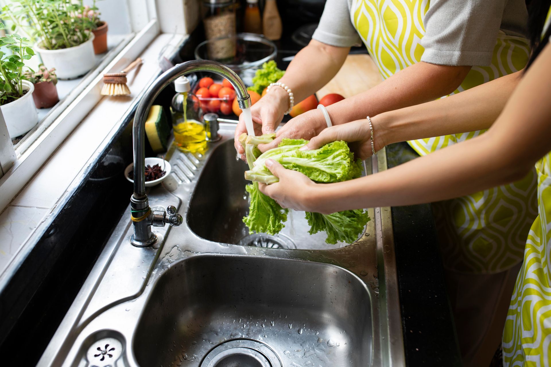 Women washing vegetables at the sink