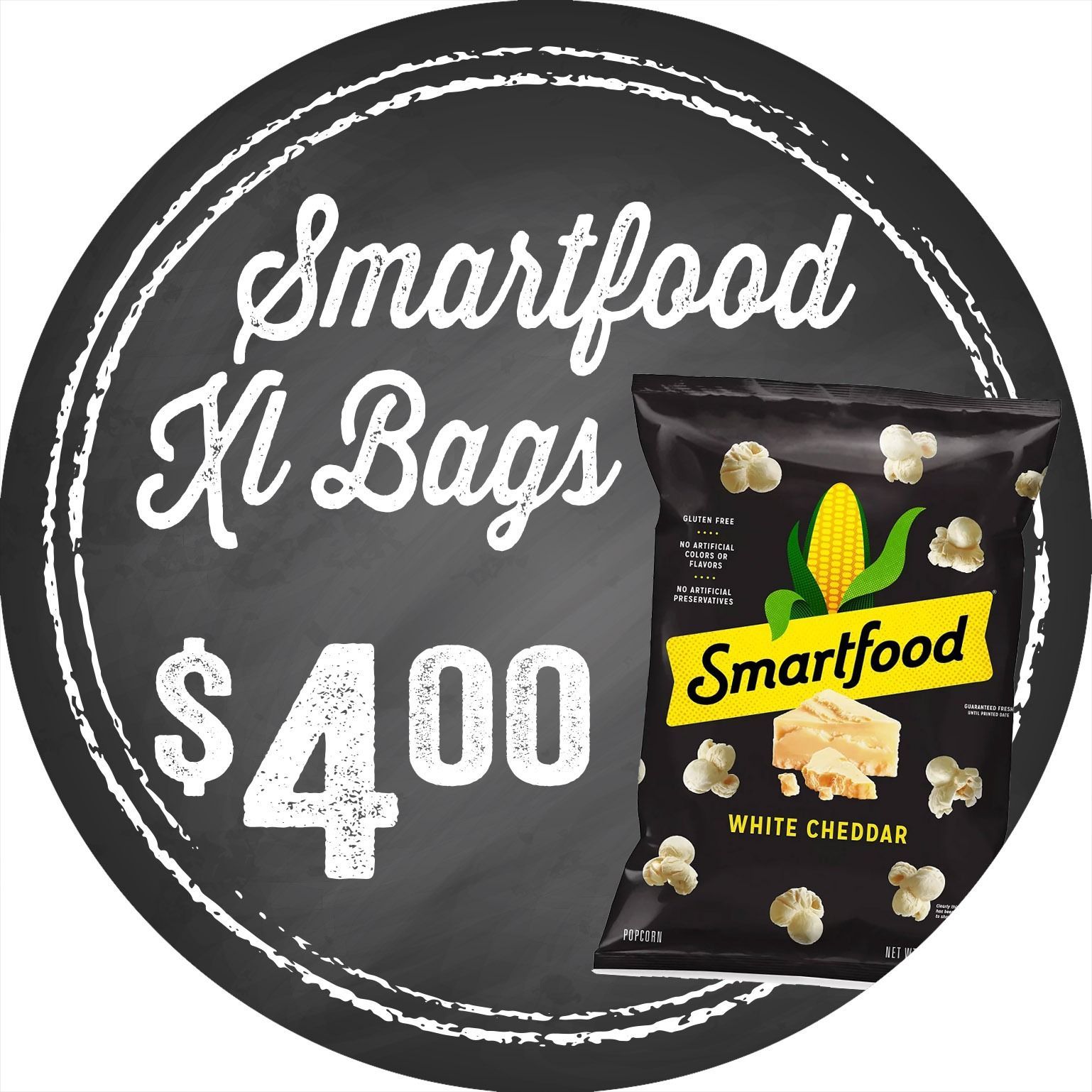 Smartfood XL Bags sign with white text, $4.00 price, and a black cheddar popcorn bag on a dark background