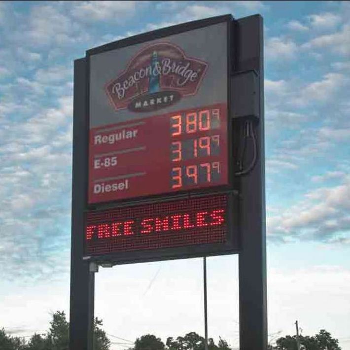 Gas station price sign with fuel prices and red LED “FREE SMILES” message