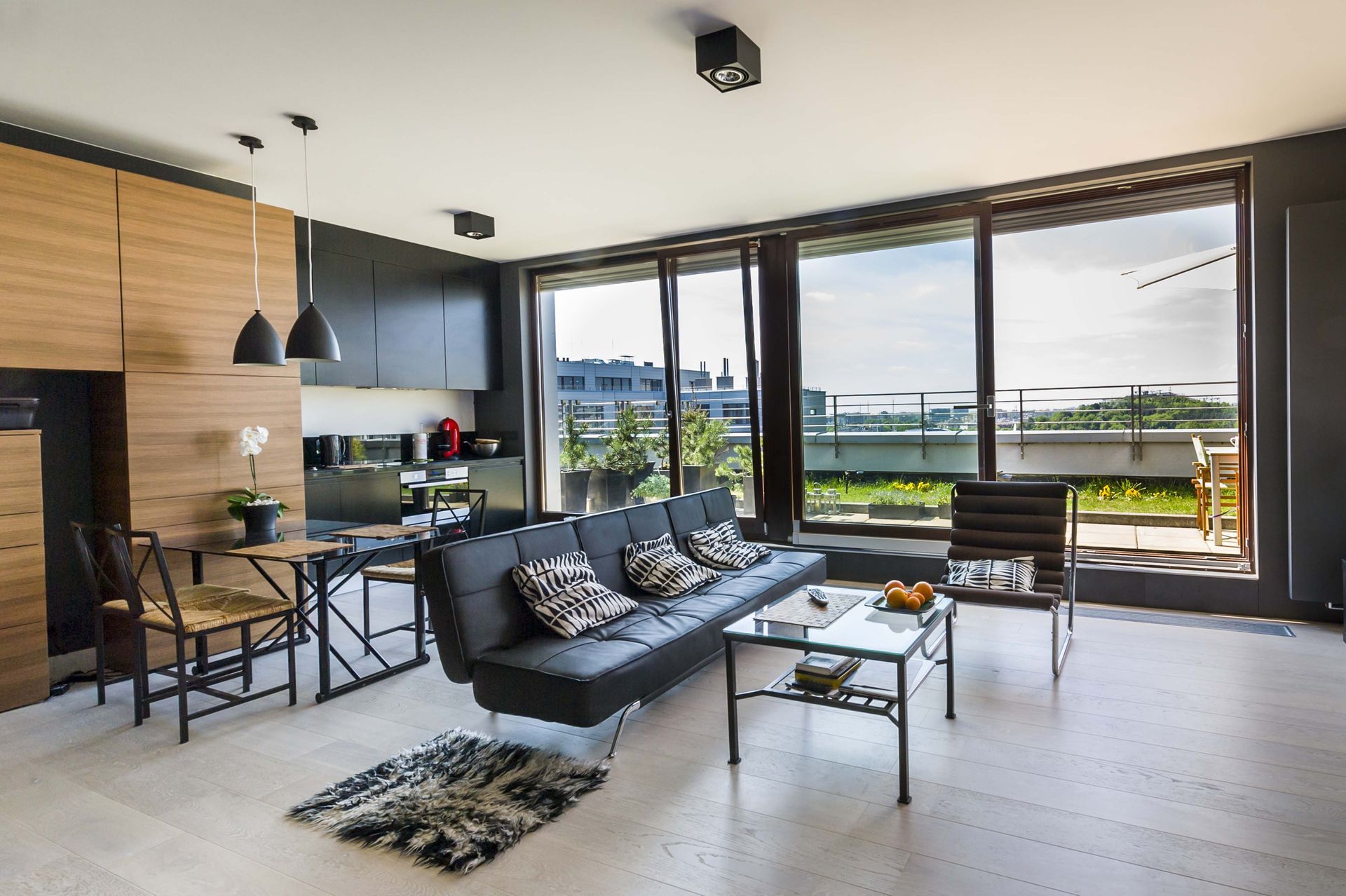 Overhead view of a modern living space with a spiral staircase, hardwood floors, and large windows.