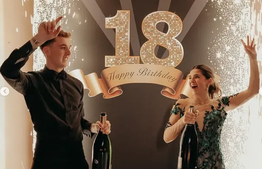 Due persone che festeggiano il diciottesimo compleanno con champagne e coriandoli dorati.