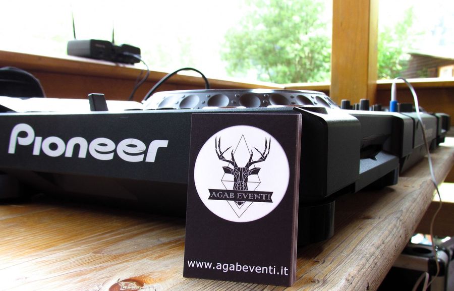 Apparecchiature audio Pioneer su un tavolo di legno con un cartellino nero con il logo davanti e una finestra luminosa dietro.