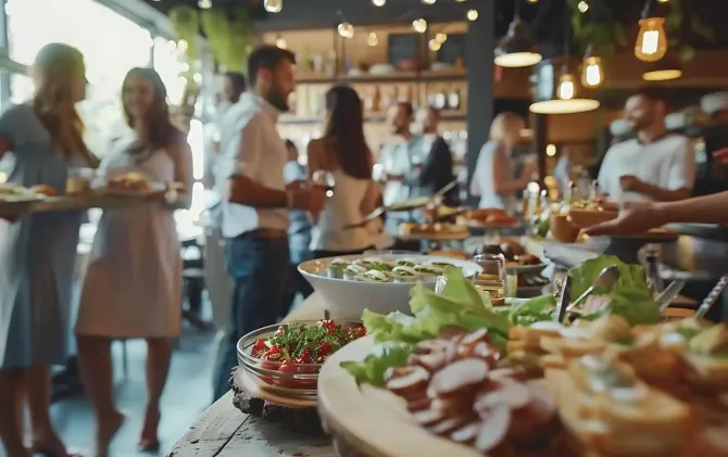 Tavolo da buffet in un vivace ritrovo al chiuso con ospiti e calde luci sospese.