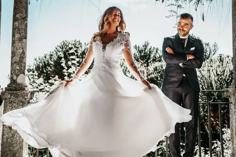 Gli sposi si scambiano gli anelli in chiesa, con gli invitati seduti alle loro spalle e un fotografo nelle vicinanze.