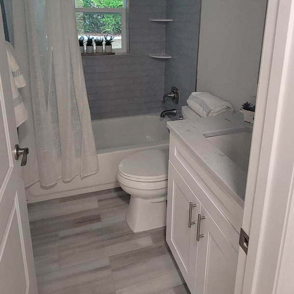 A bathroom with a toilet , sink , bathtub and shower curtain.